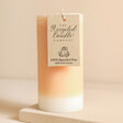 The Recycled Candle Company Blonde Amber and Honey Pillar Candle showing tag against beige coloured backdrop