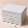 Grey Jewellery Box with Pull Drawers against beige coloured backdrop