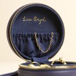 Mini Round Travel Jewellery Case in Navy open against beige coloured backdrop