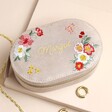 Personalised Embroidered Flowers Oval Velvet Jewellery Case with jewellery outside of case against beige backdrop