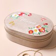 Personalised Embroidered Flowers Oval Velvet Jewellery Case with jewellery outside of case against beige backdrop