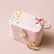 Personalised Embroidered Flowers Petite Velvet Travel Ring Box closed with jewellery outside of case against beige backdrop