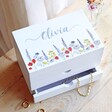 Personalised Wildflower White Jewellery Box on wooden counter with jewellery spilling out of drawers