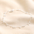 Dainty Flower Charm Anklet in Silver on top of beige coloured fabric