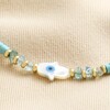 Close Up of Hamsa Hand Teal Heishi Beaded Anklet in Gold