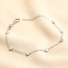 Stainless Steel Heart Charm Anklet on top of beige coloured backdrop