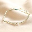 Crystal Blue and White Beaded Cord Bracelet in Gold on Beige Fabric