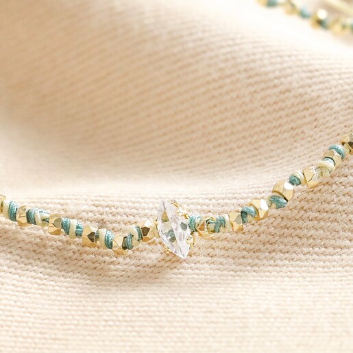 Close Up of Crystal Blue and White Beaded Cord Bracelet in Gold