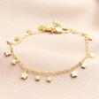 Dainty Flower Charm Bracelet in Gold on Beige Fabric