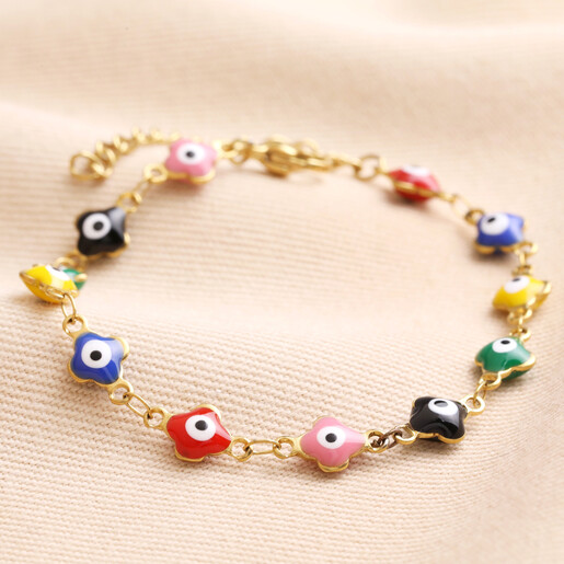 Gold Stainless Steel Colourful Enamel Evil Eye Charm Bracelet on top of beige coloured fabric