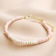 Pink and White Semi-Precious Heishi Beaded Bracelet on top of beige coloured fabric