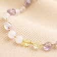Close up of stones on Pastel Semi-Precious Stone Beaded Bracelet in Gold against neutral coloured material