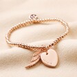 Personalised Beaded Wing Charm Bracelet in rose gold on top of neutral coloured material