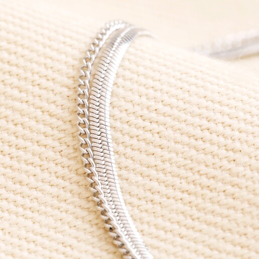Close up of Stainless Steel Layered Snake and Curb Chain Bracelet on Beige Fabric