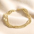 Triple Layered Dotted Chain Bracelet in Gold on top of beige coloured fabric