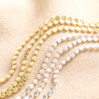Triple Layered Dotted Chain Bracelet in Gold with silver version on neutral coloured fabric