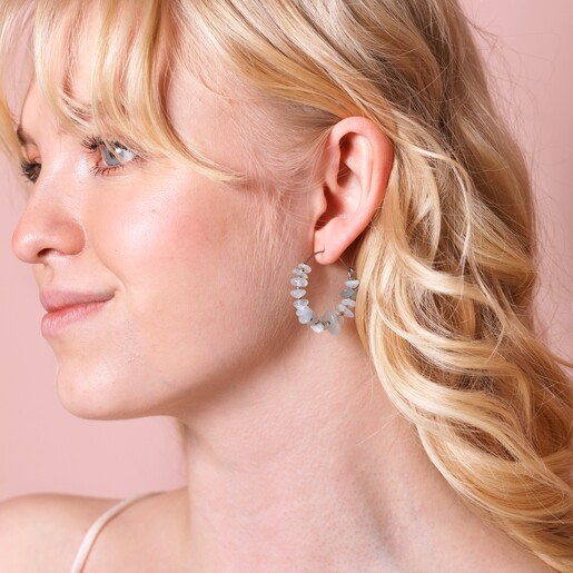 Earrings on Model Stainless Steel Blue Crystal Chip Hoop Earrings on model against pink backdrop