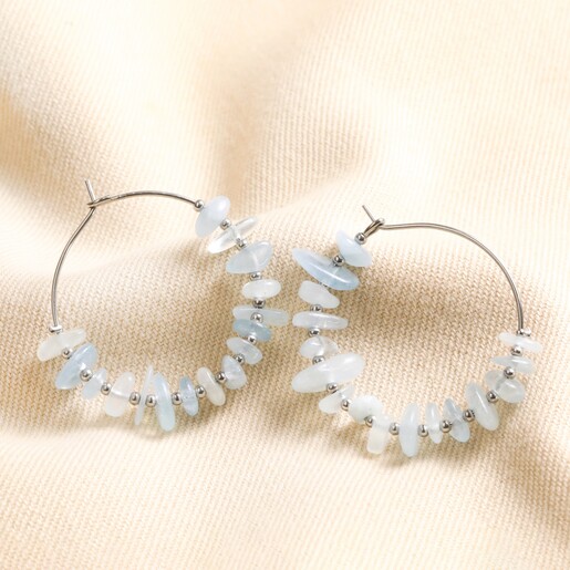 Stainless Steel Blue Crystal Chip Hoop Earrings Stainless Steel Blue Crystal Chip Hoop Earrings laid on top of beige coloured fabric