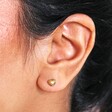 Close Up of Gold Stainless Steel Tiny Round Heart Stud Earrings on Model