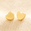 Gold Stainless Steel Tiny Round Heart Stud Earrings on Beige Fabric