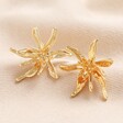 Oversized Sea Flower Stud Earrings in Gold on top of beige coloured fabric