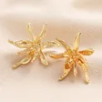 Oversized Sea Flower Stud Earrings in Gold on top of beige coloured fabric