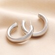 Stainless Steel Chunky Huggie Hoop Earrings on Beige Fabric