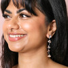 Flower Petal Drop Earrings in Silver on model smiling against beige backdrop