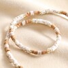 Brown and White Heishi Beaded Necklace arranged on top of neutral coloured fabric