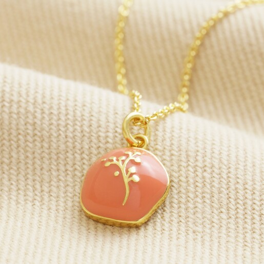 Orange Enamel Organic Flower Pendant Necklace in Gold on Beige Fabric