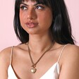 Gold Stainless Steel Chunky Toggle and Heart Pendant Necklace on model against beige coloured backdrop