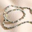Semi-Precious Stone Beaded Necklace in Green and Brown on Beige Fabric