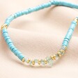Blue Semi-Precious Heishi Beaded Necklace in Gold on Beige Fabric