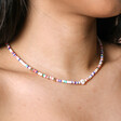 Close up of Multicoloured Heishi and Daisy Charm Beaded Necklace in Gold on model