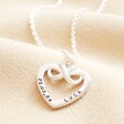 Close up of Personalised Sterling Silver Infinity Heart Pendant Necklace against beige coloured fabric
