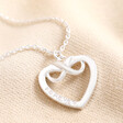Personalised Sterling Silver Infinity Heart Pendant Necklace with clean engraving against neutral material