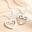 Personalised Sterling Silver Infinity Heart Pendant Necklaces with clean and blackened engravings against beige fabric