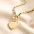 Gold Stainless Steel Chunky Toggle and Heart Pendant Necklace on top of beige coloured material