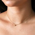 Close up of Gold Stainless Steel Tiny Round Heart Charm Necklace on model