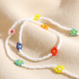 Colourful Daisy White Beaded Necklace on top of neutral coloured fabric