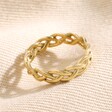 Gold Stainless Steel Braided Band Ring on top of beige coloured fabric