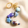 Under the Sea Ceramic Ocean Keyring arranged on top of neutral coloured fabric