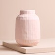 Small Pastel Pink Ceramic Matte Textured Vase on top of raised surface with beige backdrop