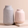 Medium Grey Ceramic Matte Textured Vase next to pink version against beige backdrop