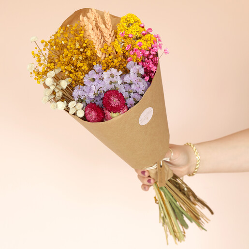 Model holding Bright Market Style Dried Flower Bouquet against beige coloured background