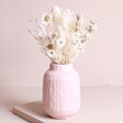 Fresh White Dried Flower Posy arranged in vase against beige backdrop