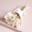 Fresh White Dried Flower Posy inside of wrapping on beige backdrop