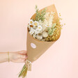Model holding Natural Market Style Dried Flower Bouquet in front of neutral backdrop