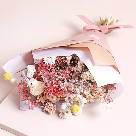 Peachy Haze Dried Flower Bouquet inside of paper on top of beige backdrop