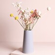 Peachy Haze Dried Flowers Letterbox Gift arranged in vase against beige backdrop